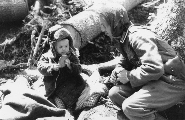Немецкий солдат угостил хлебом русского мальчика. 